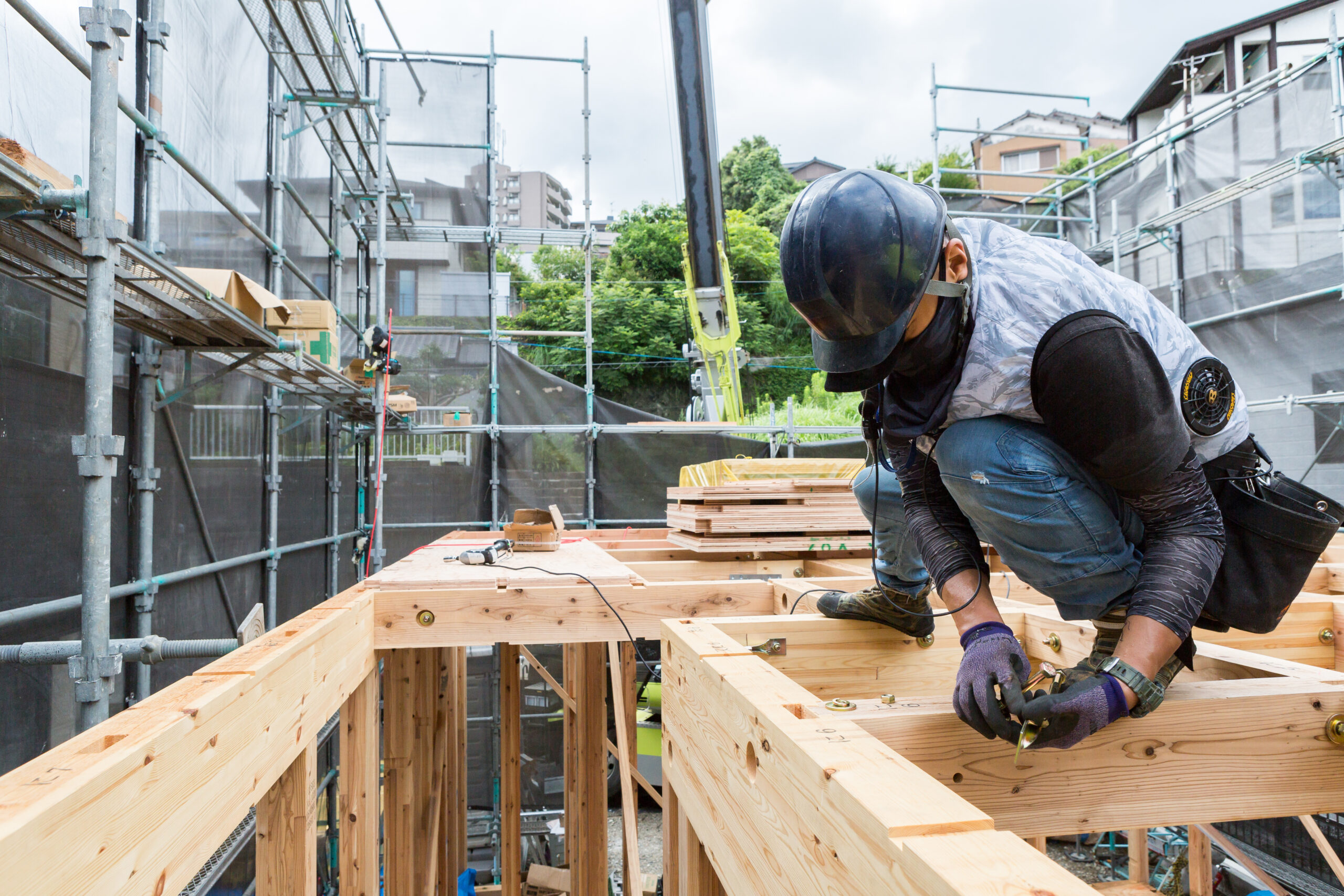 上棟した骨組みで接合金物を締める建方の作業